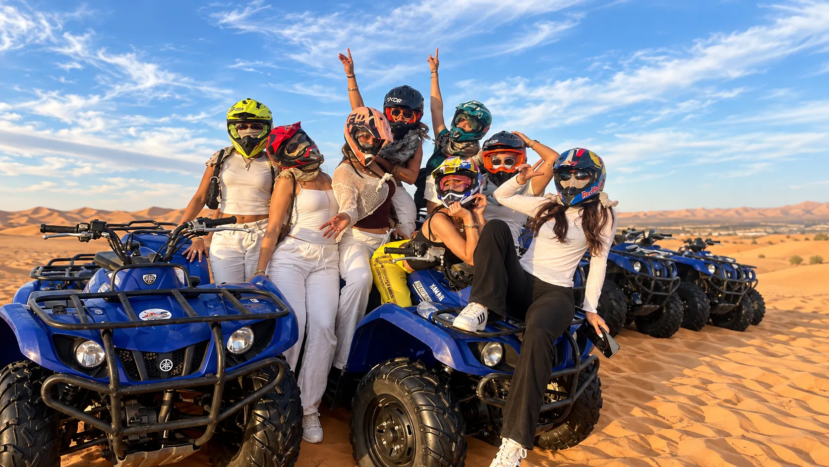 Group posing with quad bikes on sandy terrain